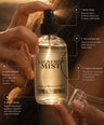 A hand holds a clear glass bottle of Magnesium Mist topical mineral spray, spraying a fine mist. The image features a warm, golden-brown background with text callouts detailing the benefits of the spray.