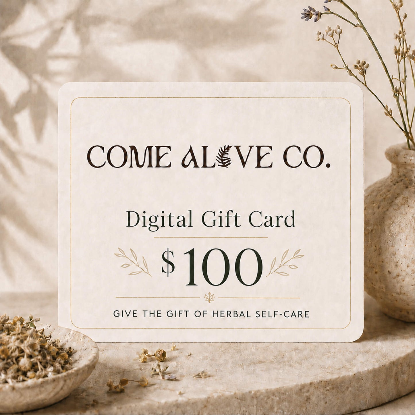 Come Alive Co. $100 digital gift card for herbal self-care, displayed on a cream card with botanical accents, dried herbs, and luxury wellness styling.