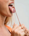 Using a copper tongue scraper as part of a morning Ayurvedic oral hygiene ritual to support fresh breath and digestion